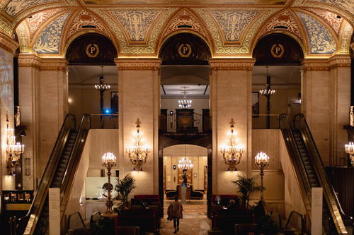 The lobby of a large building with ornate ceilings.