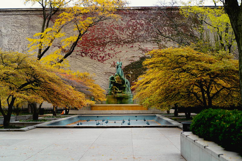 A statue in a park surrounded by trees.