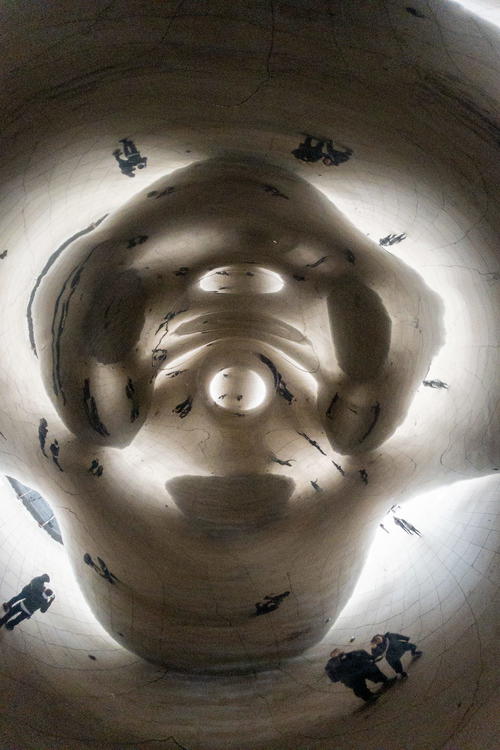 A group of people are standing inside of a large sculpture.