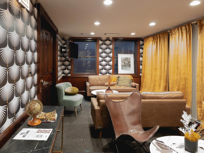 A living room in Chicago with brown leather furniture and yellow wallpaper.