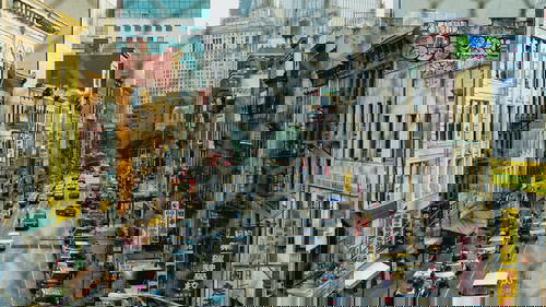 A view of a city street near the Manhattan Bridge from a fence.