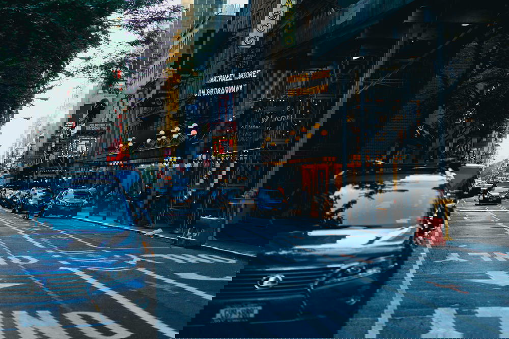 A car is parked on a city street in NYC's Times Square.