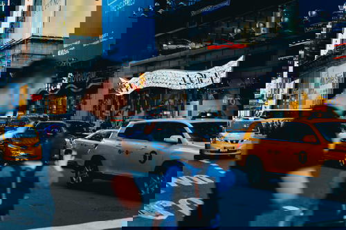 A crowd of pedestrians navigating Times Square in NYC.