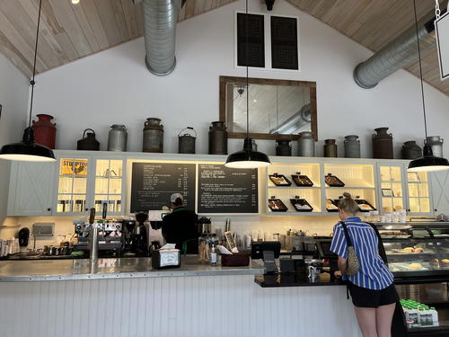 A woman is standing at the counter of a coffee shop in Litchfield, Connecticut.