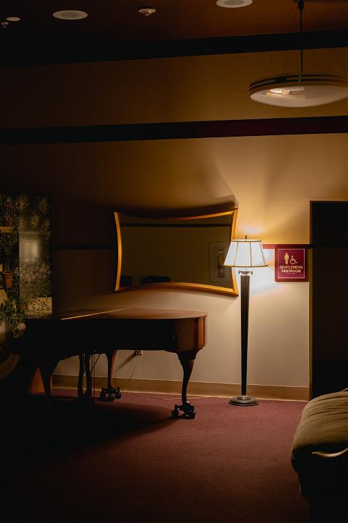 A room with a grand piano and a vintage lamp in Pittsfield, Massachusetts.