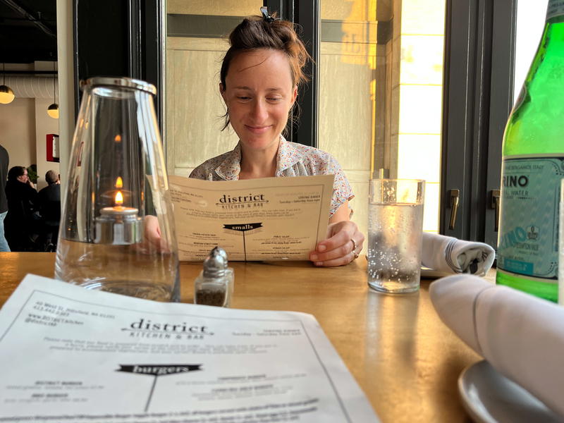 A woman sitting at a table reading a menu in Pittsfield, Massachusetts.