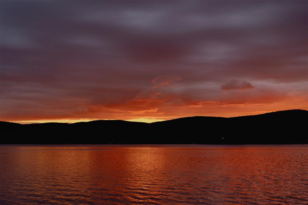 A sunset over a lake with mountains in the background near Pittsfield, Massachusetts.