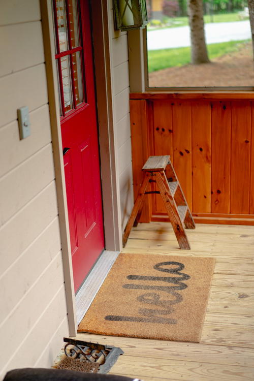 A wooden porch with a red door in The Catskills, New York.