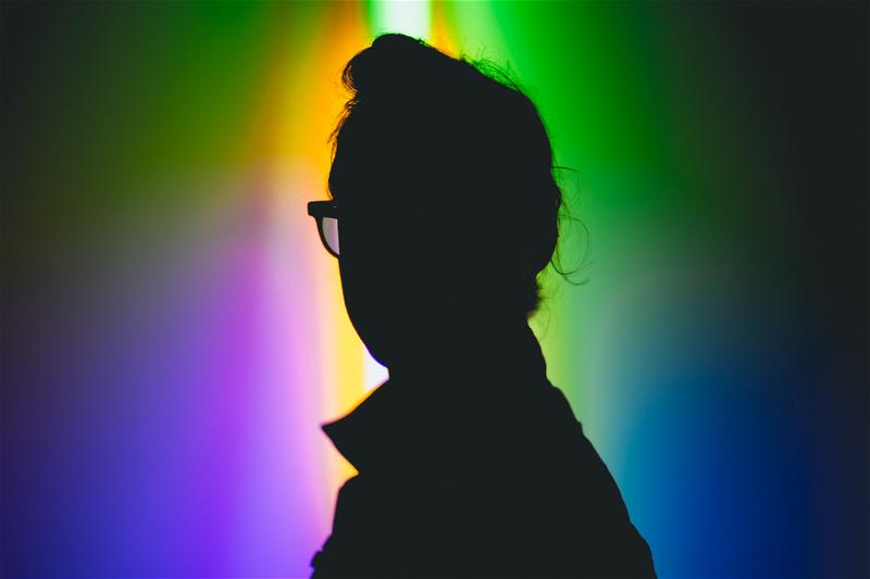 A silhouette of a person in front of a rainbow light in Beacon, New York.