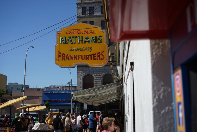 A group of people walking down a NYC street with a sign.