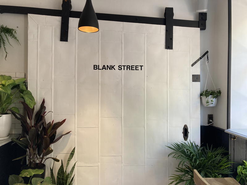A white door with the words Blank Street and NYC on it.