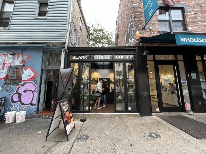 A storefront with graffiti on a street corner in NYC.