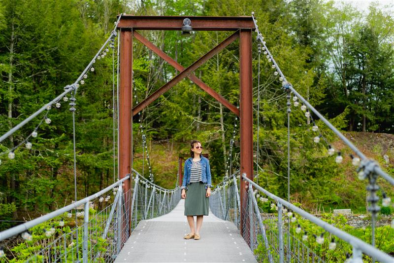 Woman standing on the suspension bridge at Antrim Streamside in Livingston Manor in the Catskills