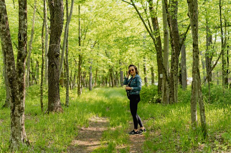 Woman wearing a jean jacket on a hiking path at Antrim Streamside in Livingston Manor