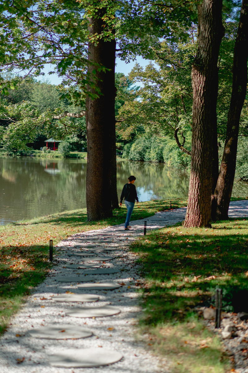 Woman walking in the morning between trees on a path in upstate New York