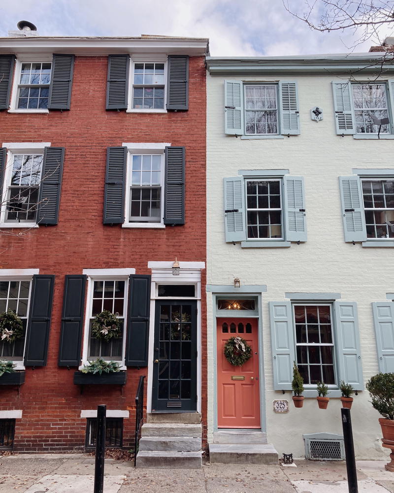 A row of houses with shutters on the front door.