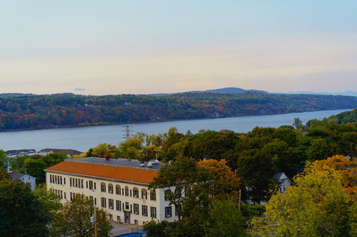 A hilltop building in NYC overlooking a body of water.