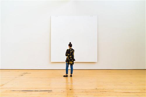 A woman standing in front of a large white canvas in NYC.