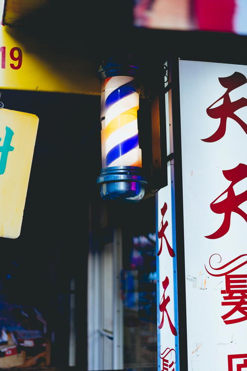 A barber shop sign in NYC with Chinese writing.
