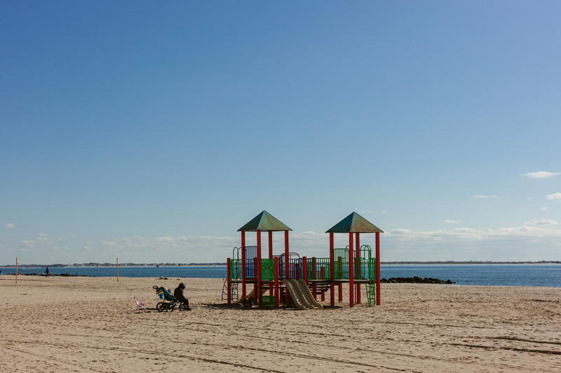 A sandy beach with a playground set up in NYC.