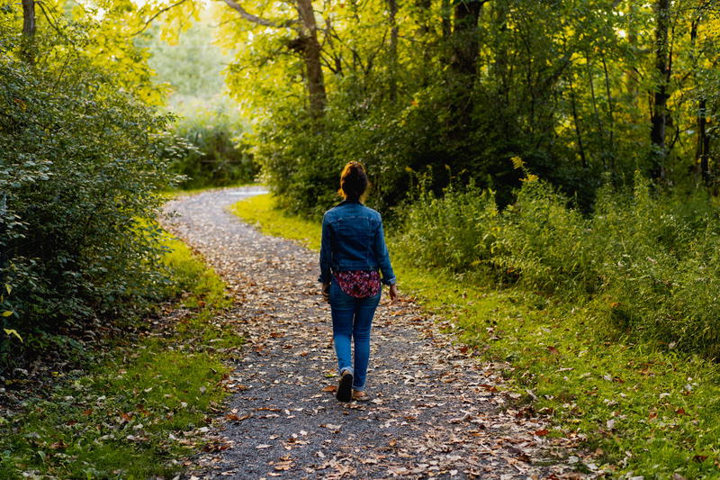 A woman walking down a path in the woods near Hudson, New York.