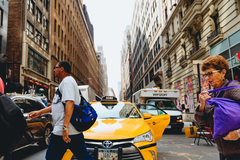 A group of people walking down a city street in NYC.