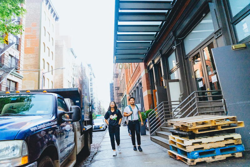 Two women walking down a city street in NYC.