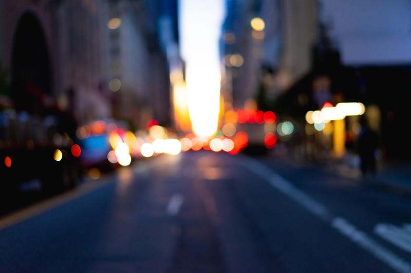 A blurry image of a city street in NYC at dusk.