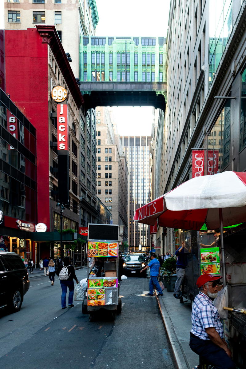 A man is selling food on a street in NYC.