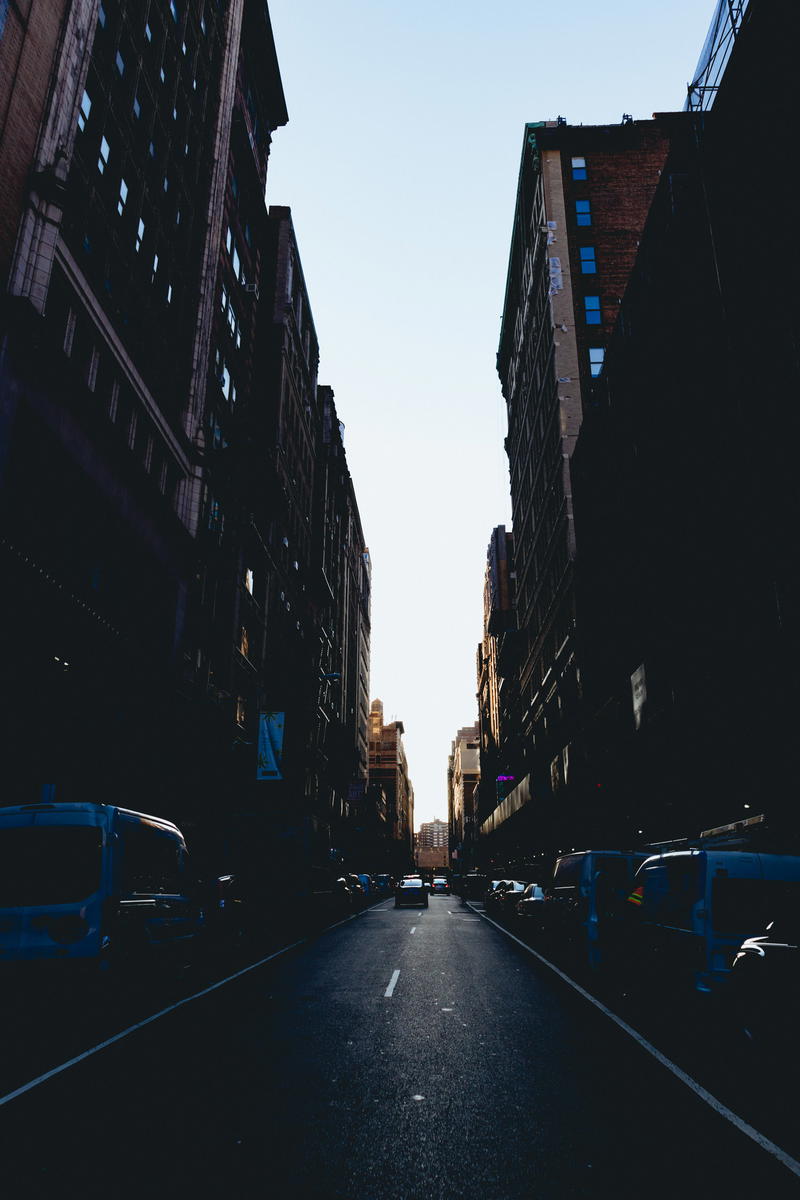 A city street in NYC with cars parked on it.