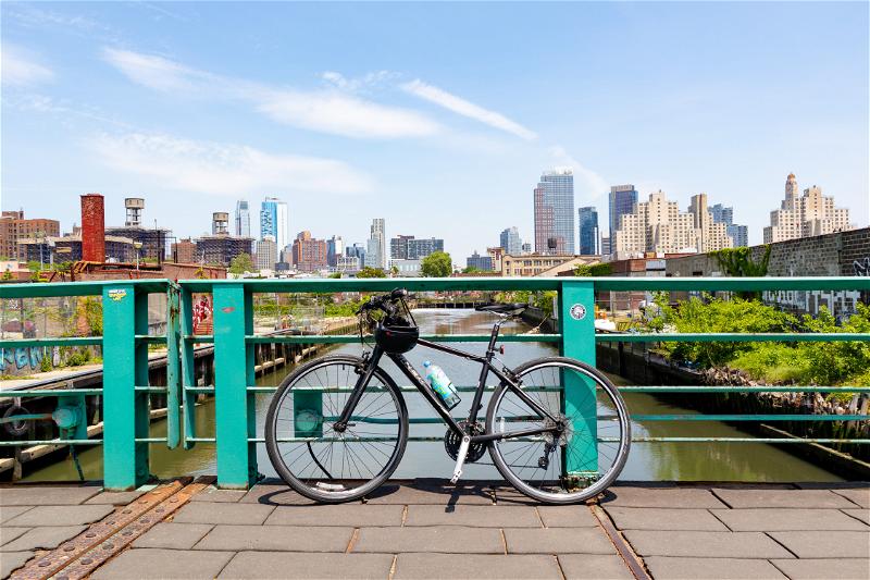 In NYC, a bike rests against a railing.