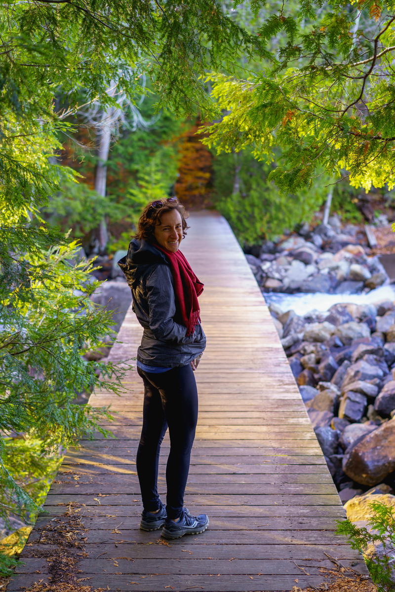 A woman standing on a wooden bridge in Lake Placid.