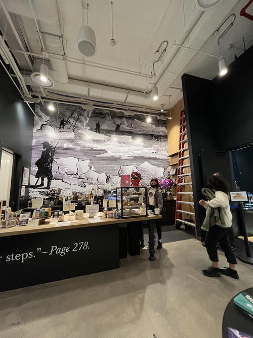A store in NYC with a mural on the wall.