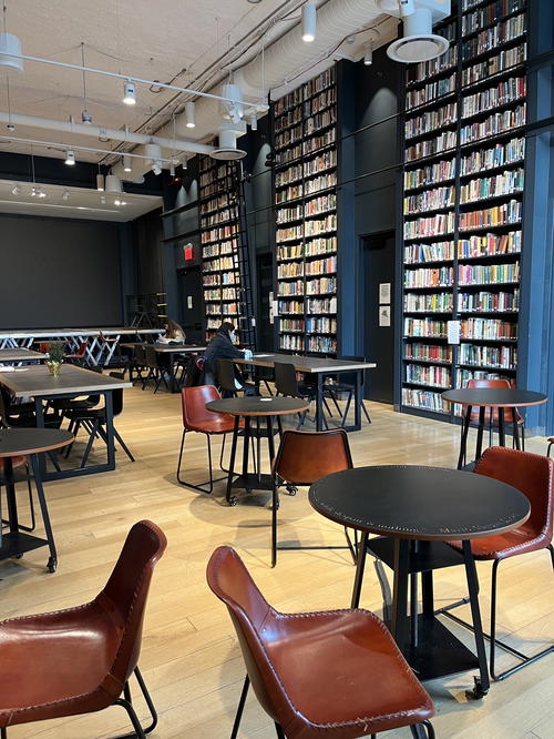 A spacious library in New York City with ample bookshelves and tables.