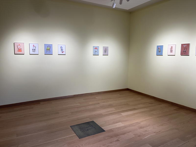 A NYC room with several paintings on the wall.