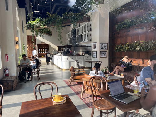 People are sitting at tables in a coffee shop in NYC.