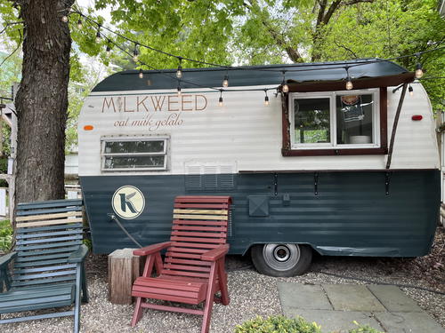 The milkweed trailer is parked in front of a tree in Livingston Manor, New York.
