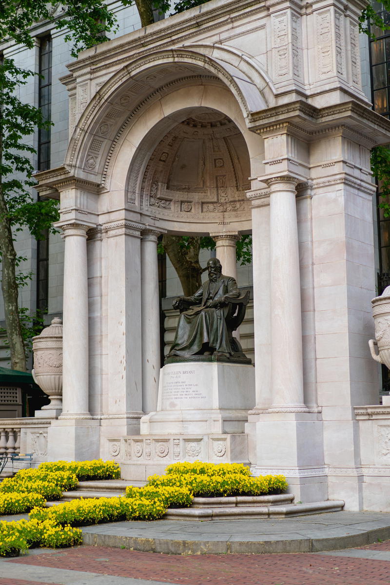 A statue of a man in front of a building in NYC.