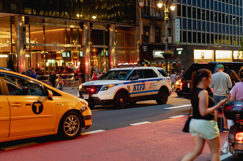 A group of people walking down a city street in NYC.