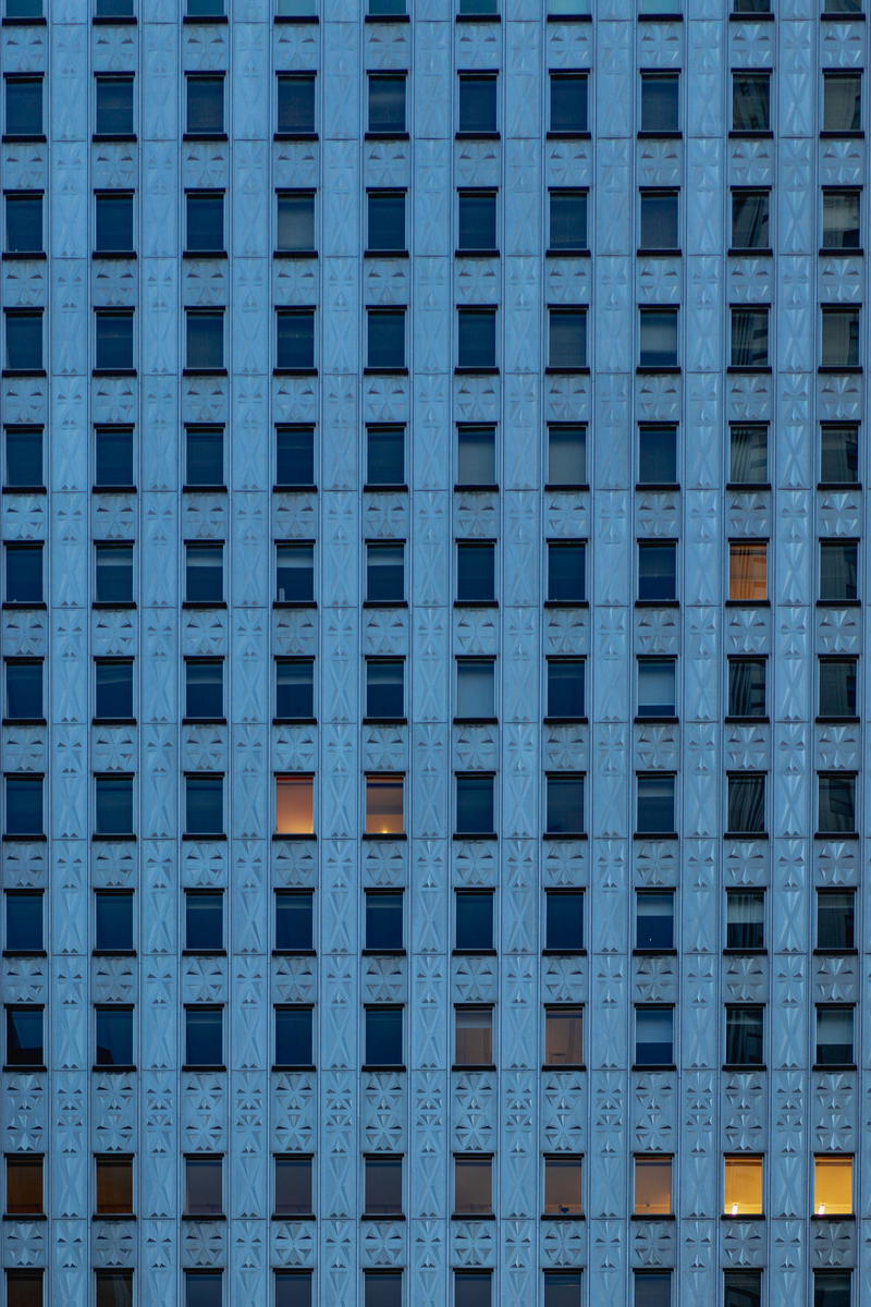A skyscraper in New York City filled with countless windows.