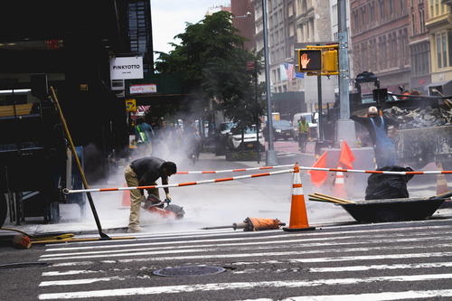 A man using a machine on a street in NYC.