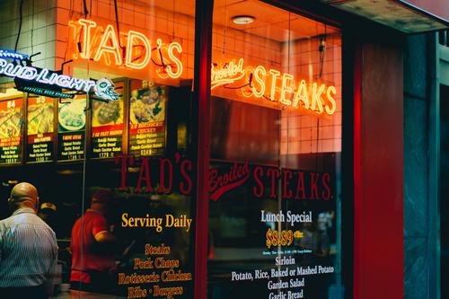 A NYC restaurant with a sign that says tad steaks.