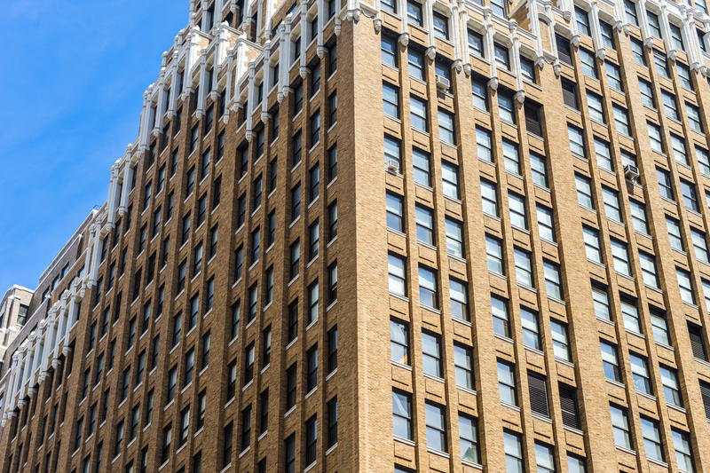 A tall building with many windows in NYC.