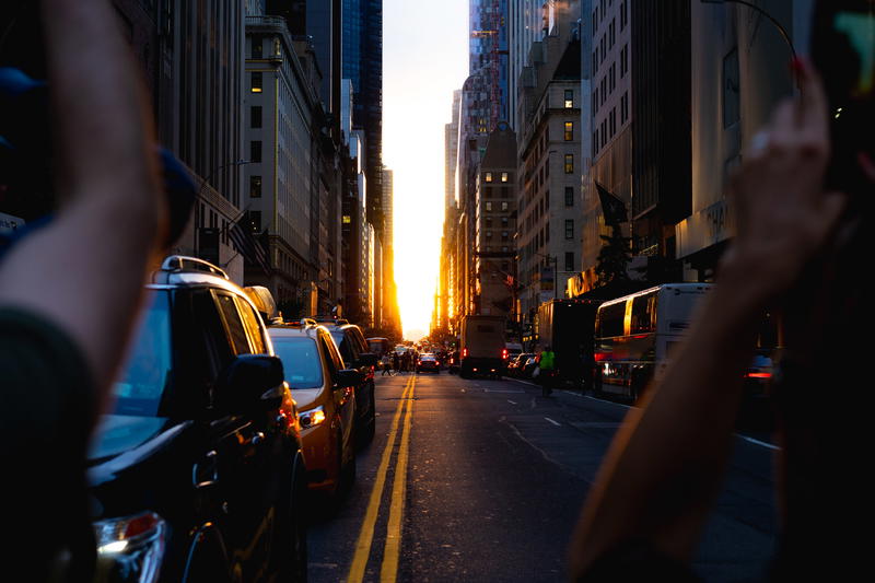 A person capturing a sunset picture of a New York City street in Manhattan.