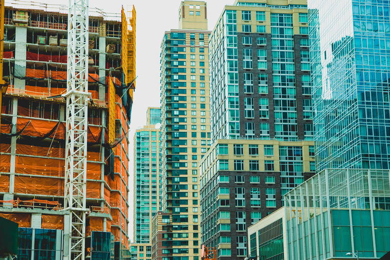 Construction site with orange and blue glass buildings