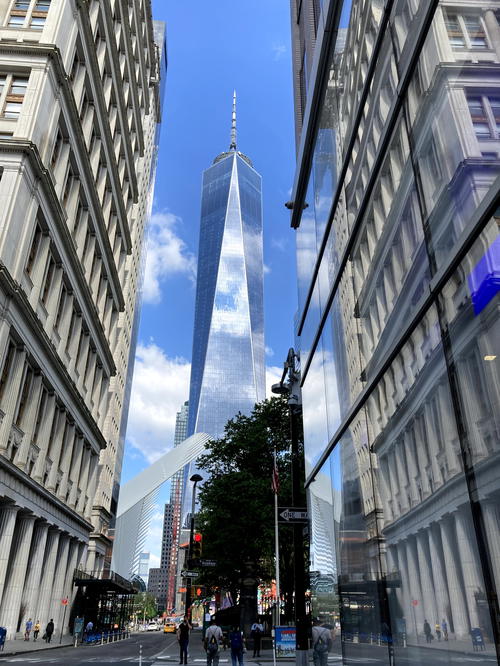 The world trade center is reflected in the glass of a building in NYC.