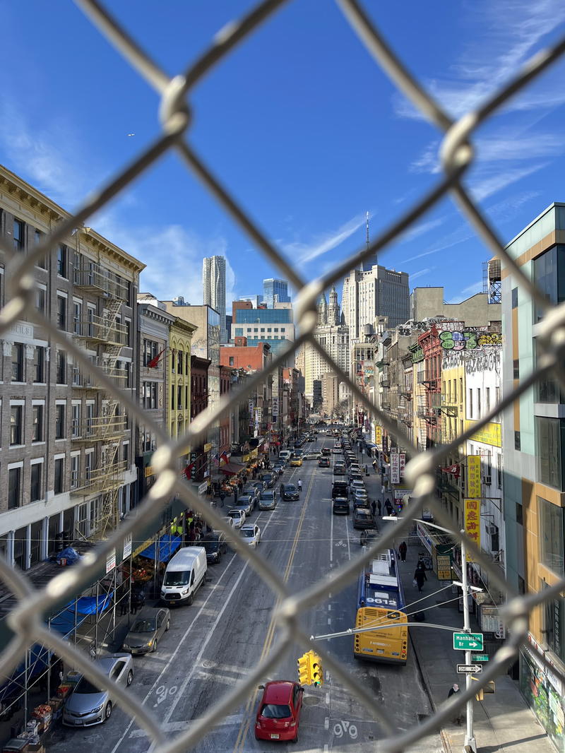 A view of NYC through a chain link fence.