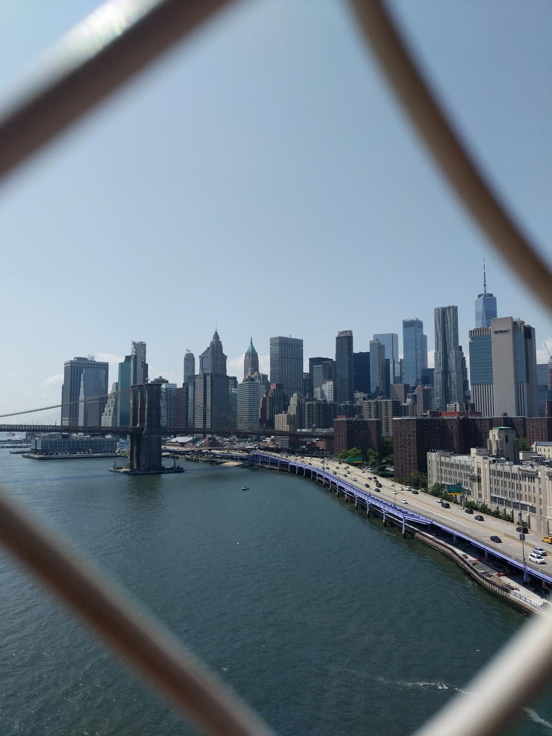 View of NYC through a fence from Brooklyn Bridge.