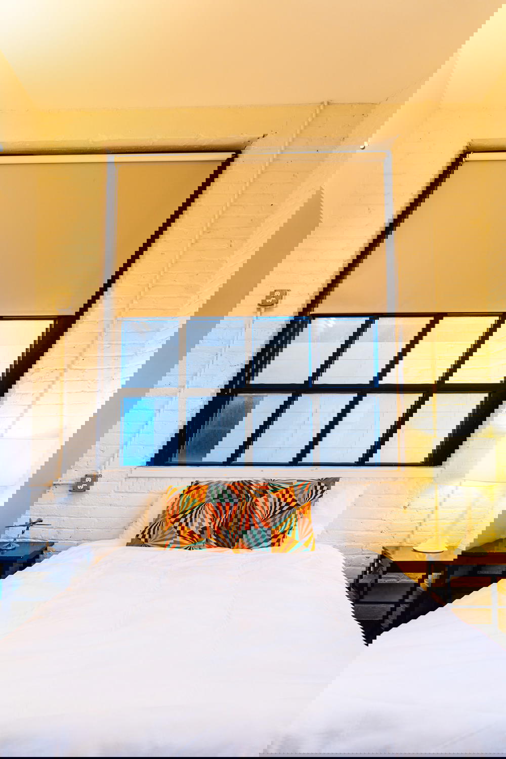 Industrial chic hotel private room queen sized bed with white comforter