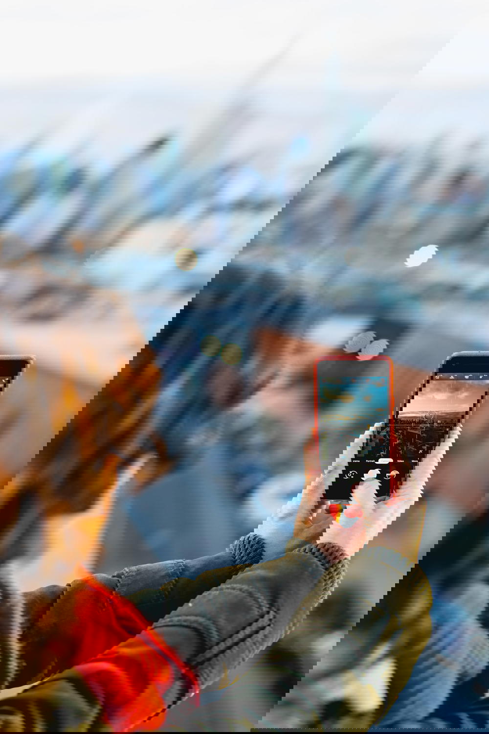 Woman taking a photo of a city view from a rooftop